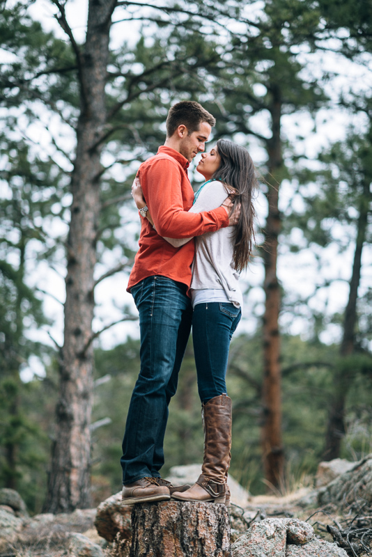 Evergreen engagement photography kissing couple in a forest