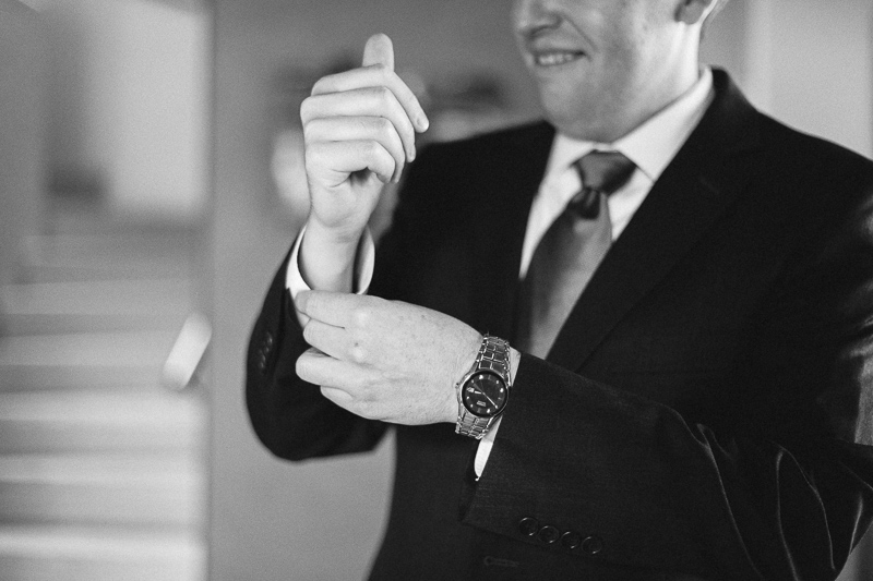 Golden Wedding Photographer groom fixing cuffs