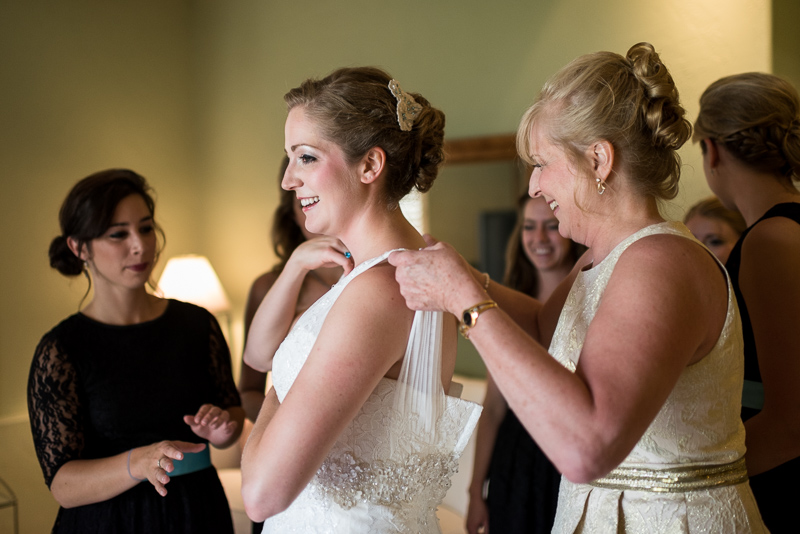 Golden Wedding Photographer bride putting on dress