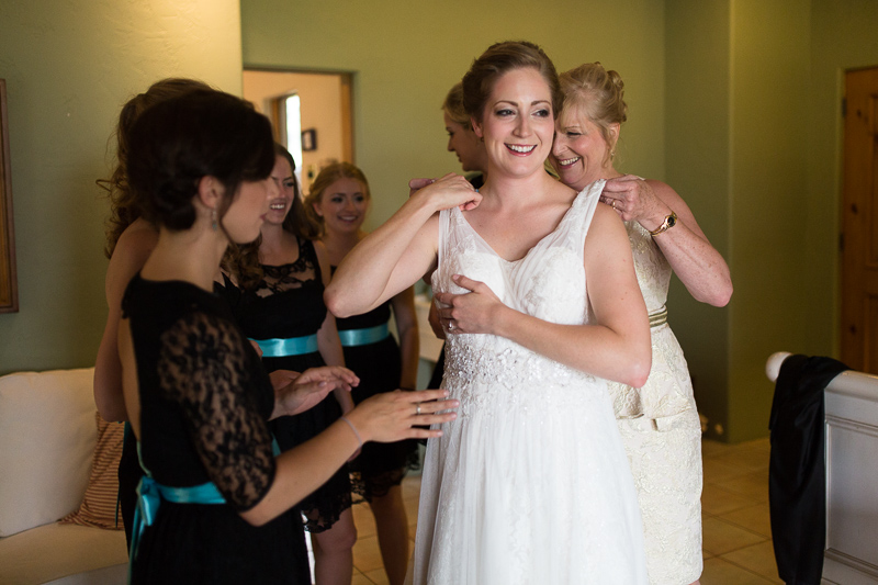 Golden Wedding Photographer bride putting on ress