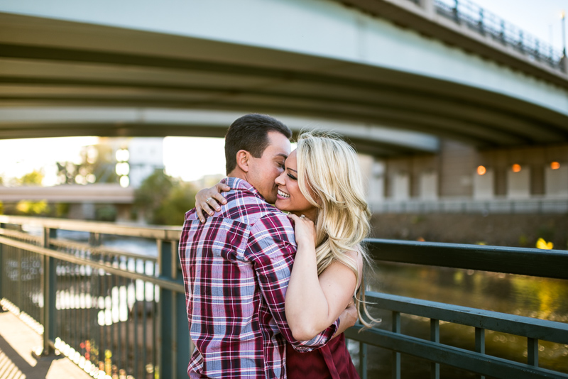 Denver Engagement Photography hugging in front of bridge