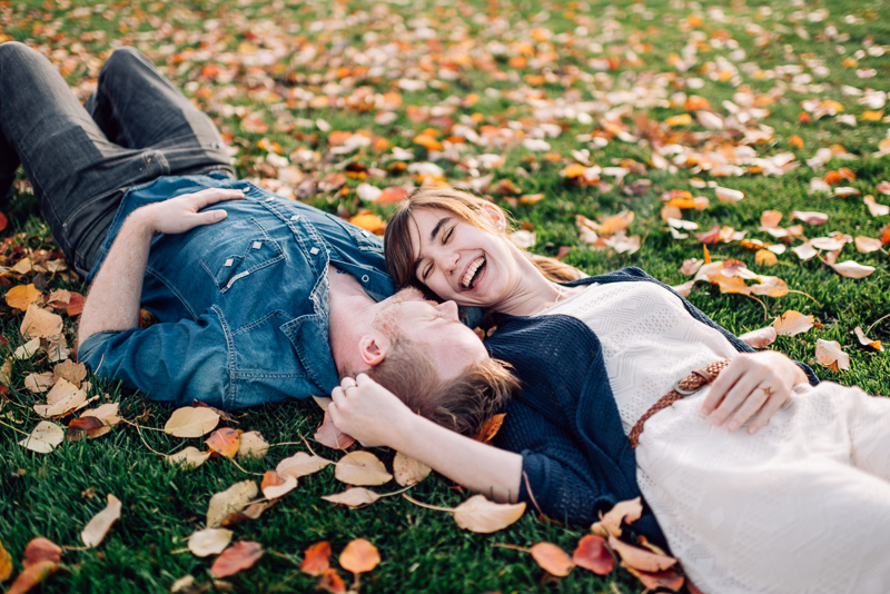 Denver Engagement Photography Chatfield Botanic Gardens lying in leaves laughing