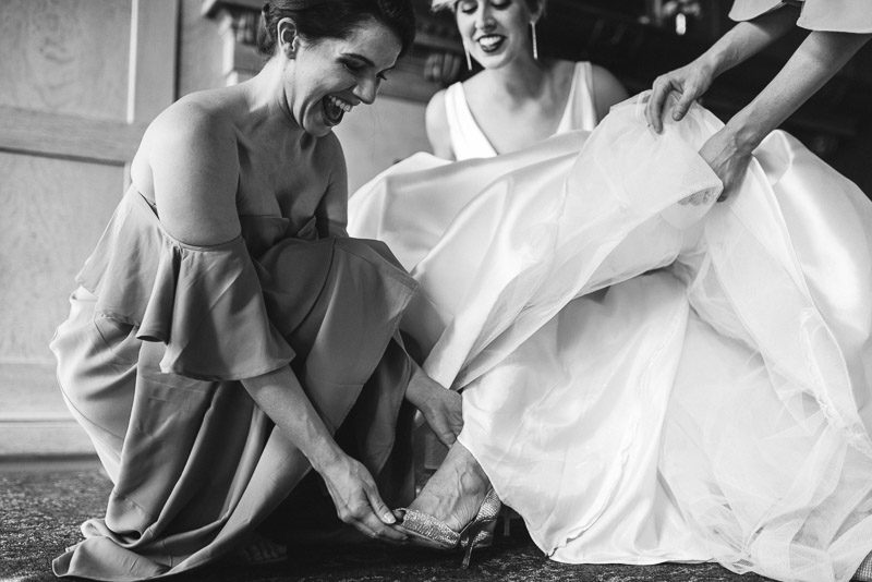 bridesmaids helping bride get dressed