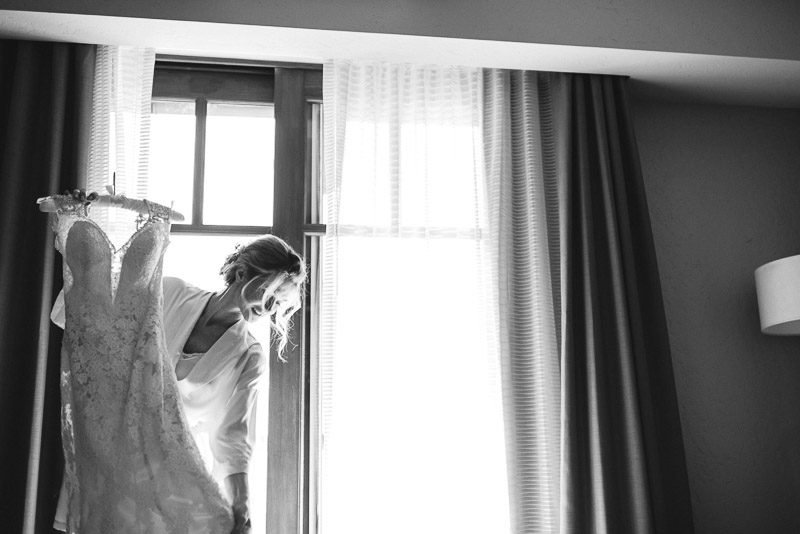 Vail Wedding Photography Camp Hale bride looking at dress